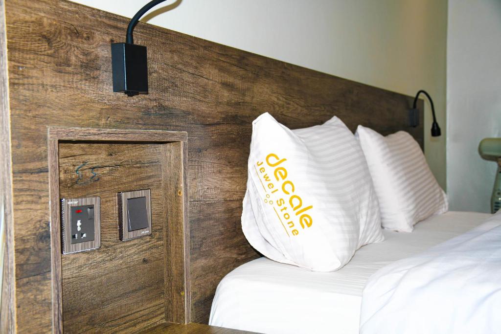 a hotel room with a bed with a wooden headboard at Decale Jewel Stone Hotel in Nairobi