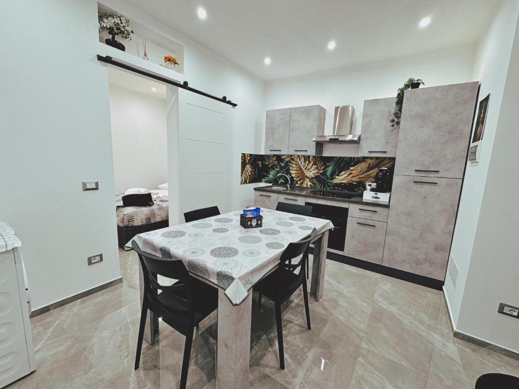 a kitchen with a table and chairs in a room at Abbate Apartments MIRI in Palermo