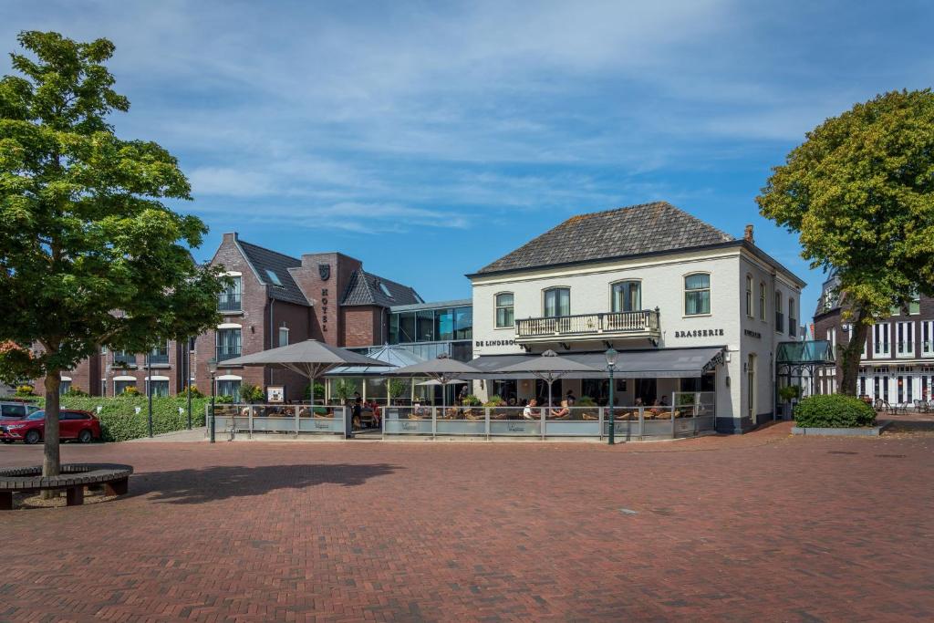 ein Gebäude mit einem Café mitten auf einer Straße in der Unterkunft Hotel De Lindeboom in Den Burg