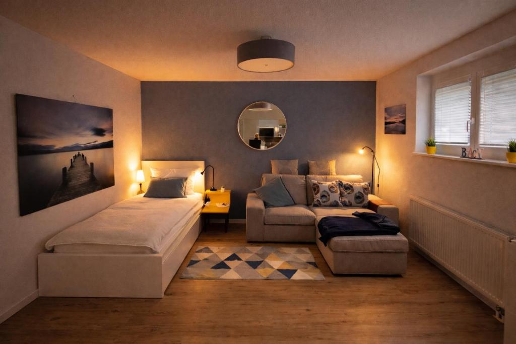 a bedroom with a bed and a couch at Apartment_BaLi in Linkenheim-Hochstetten