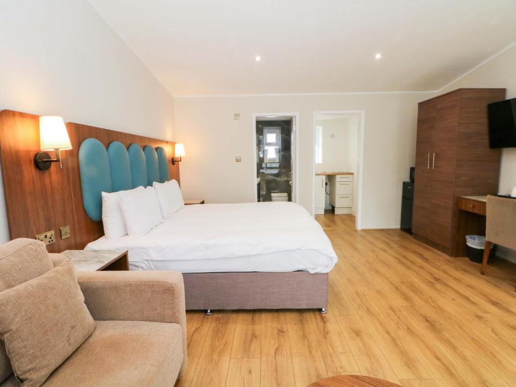 a hotel room with a large bed and a couch at Hedgehog Lodge in Chorley