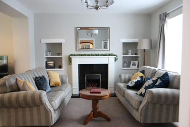 a living room with two couches and a fireplace at Charming St Davids Cottage with Cathedral Views in St. Davids