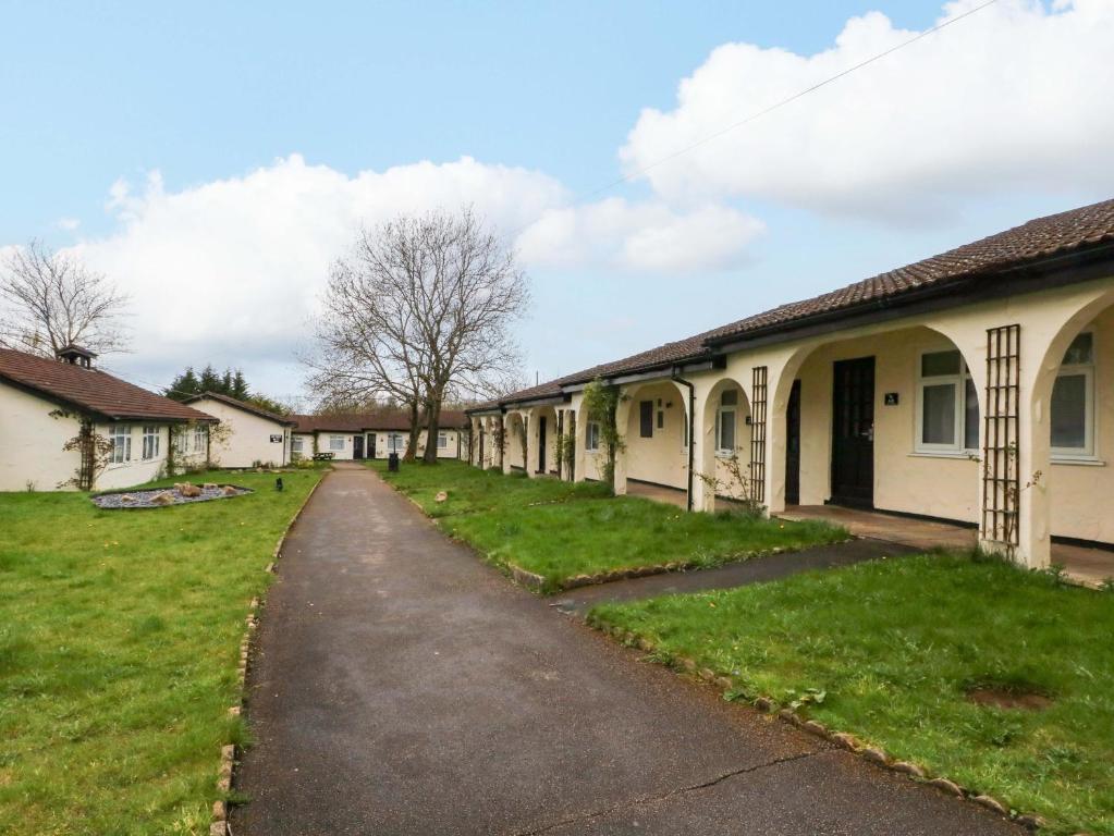 a row of houses in a yard with grass at Squirrel Lodge in Chorley