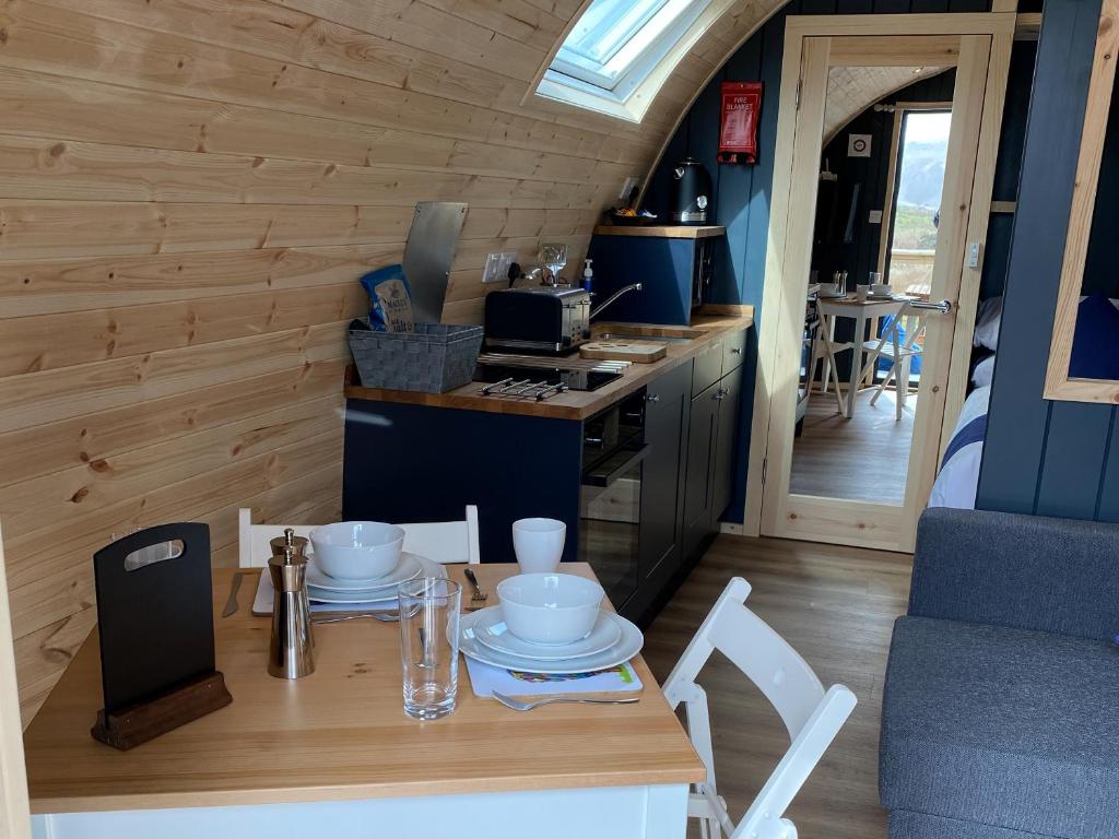 a small kitchen with a table and chairs in a tiny house at Maggie's Cabin in Oban
