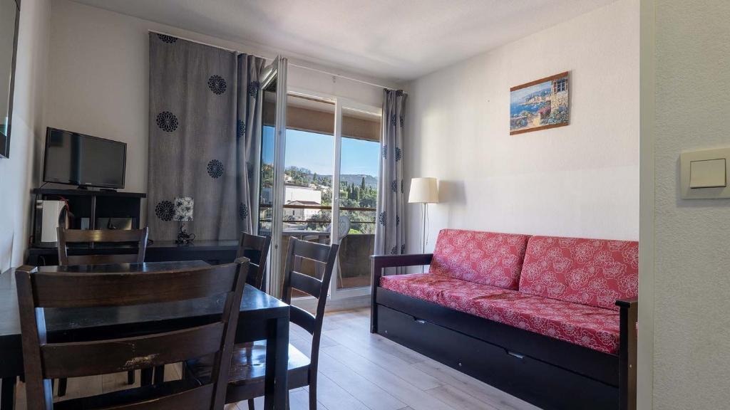 a living room with a red couch and a dining table at Virginia N 202 2P4 in Grasse