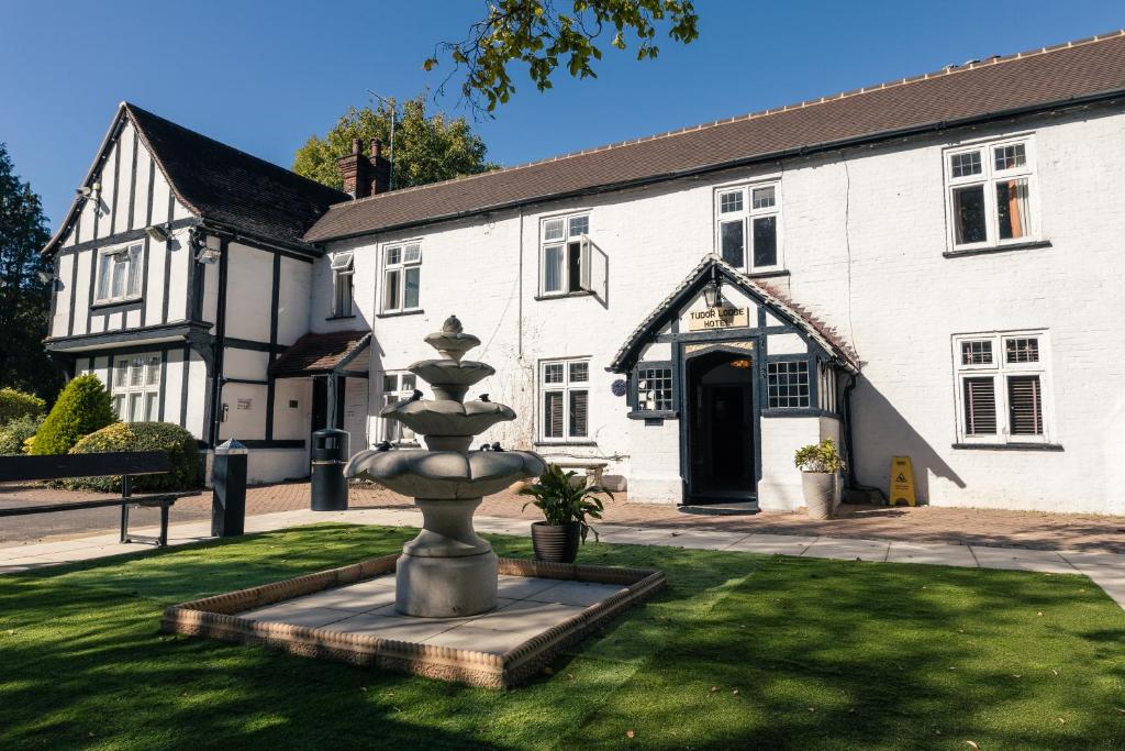 a fountain in front of a white building at The Tudor Hotel in Harrow