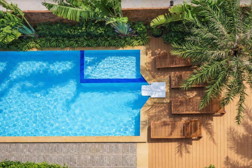 an overhead view of a swimming pool with chairs and trees at KAI Condo 1BR Pool View NBC Nai Harn in Rawai Beach