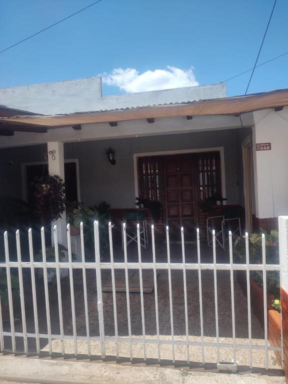 a white picket fence in front of a house at DepartamentosJYM in Federación