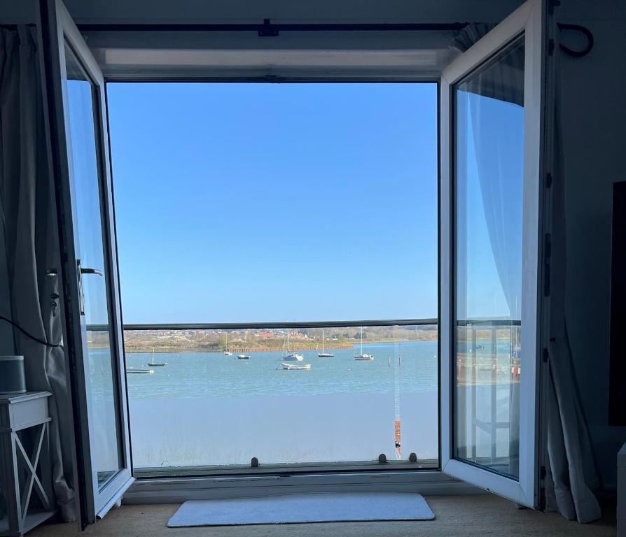 a large window in a room with a view of the water at Beach House Manningtree in Manningtree