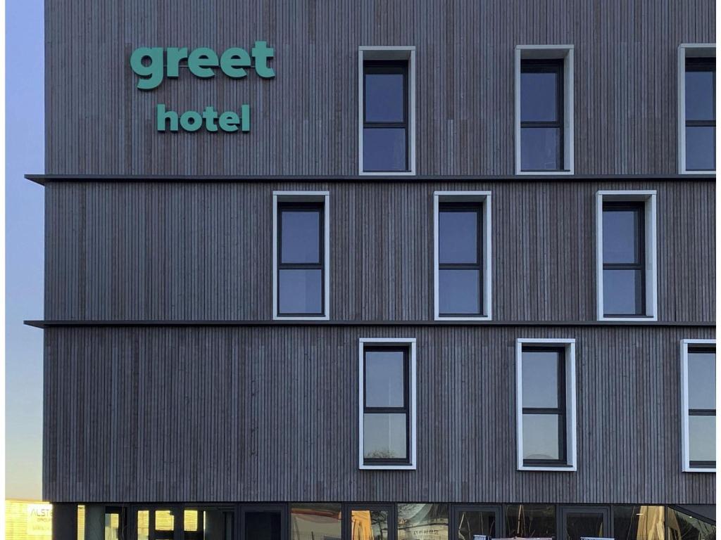 a building with a green hotel sign on it at greet Hotel Rennes Pace in Pacé