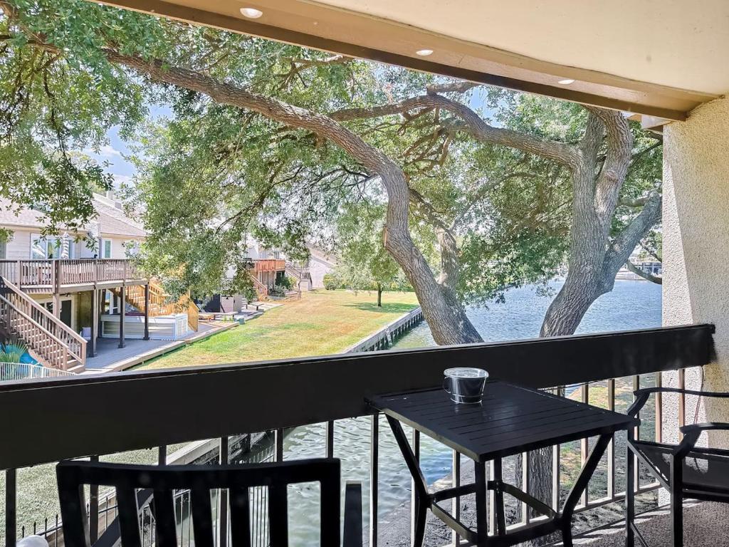 a table on a balcony with a view of the water at Lakefront Action Paddle Pickle Pool Sunset in Montgomery