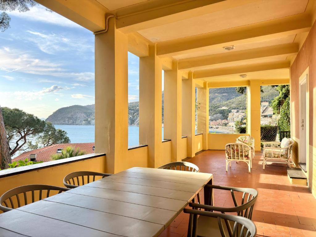 a dining room with a table and chairs on a balcony at VILLA TRAMONTO in Levanto