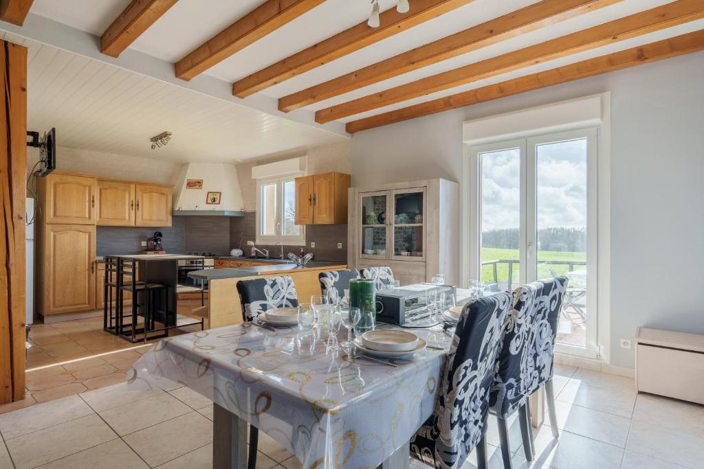 a kitchen and dining room with a table and chairs at La Clairière de Dogneville - proche Epinal in Dogneville