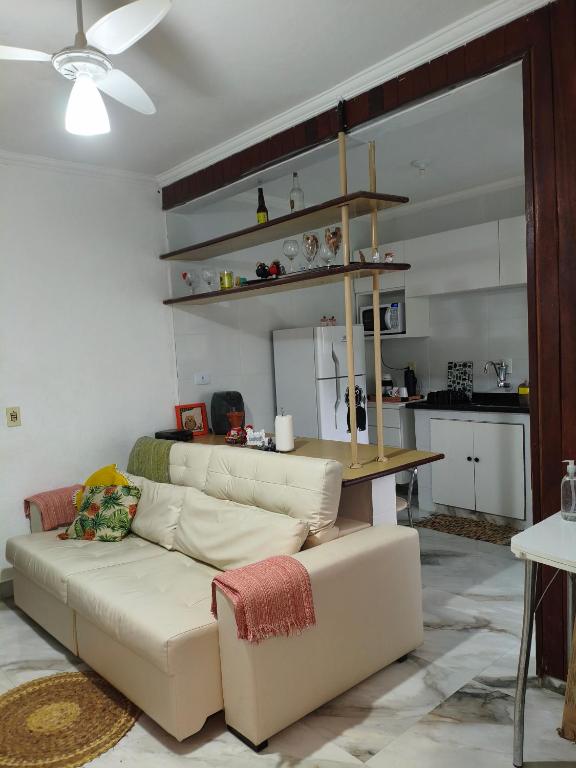 a living room with a couch and a table at Cantinho da Lu em apt inteiro 1km da praia in Bertioga