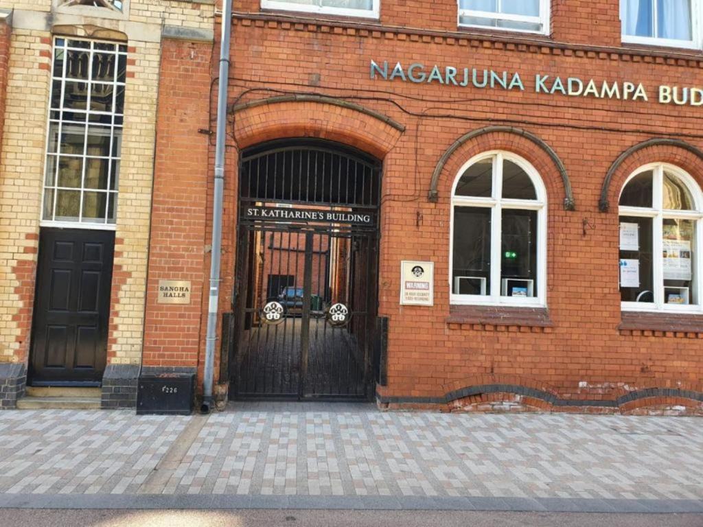 a red brick building with a large door at Sangha Hall - Private Ensuite Rooms with Shared Kitchen in Leicester
