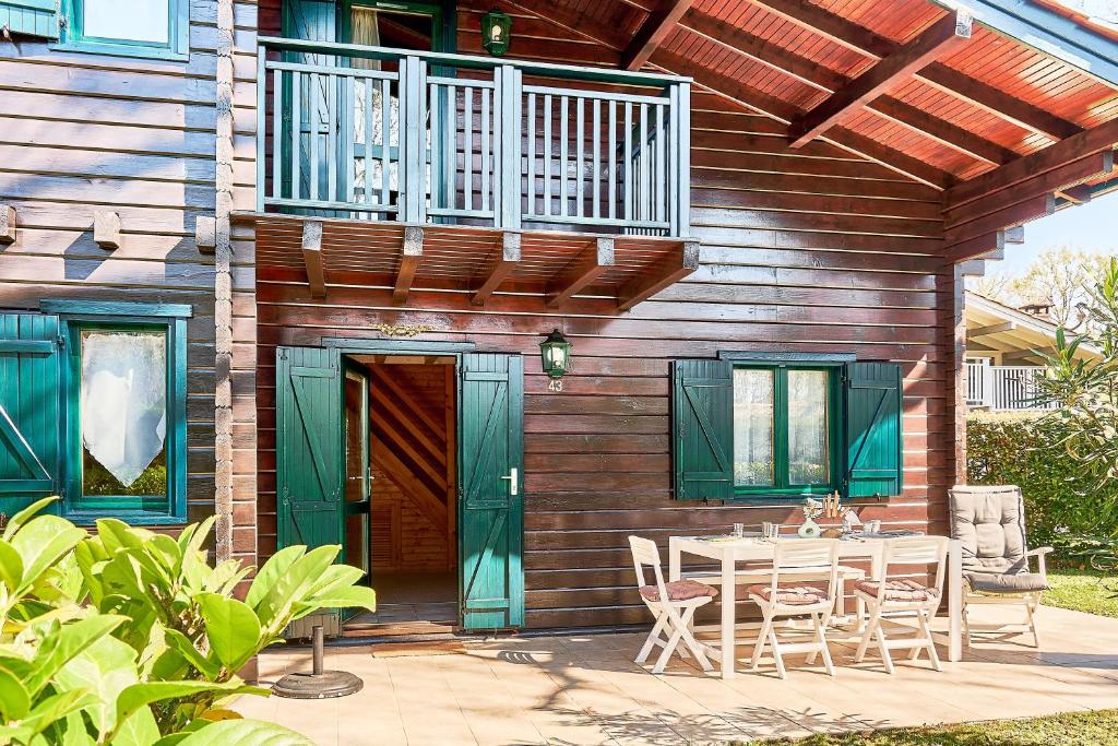 a patio with a table and chairs and a balcony at Chalet Solariale in La Teste-de-Buch