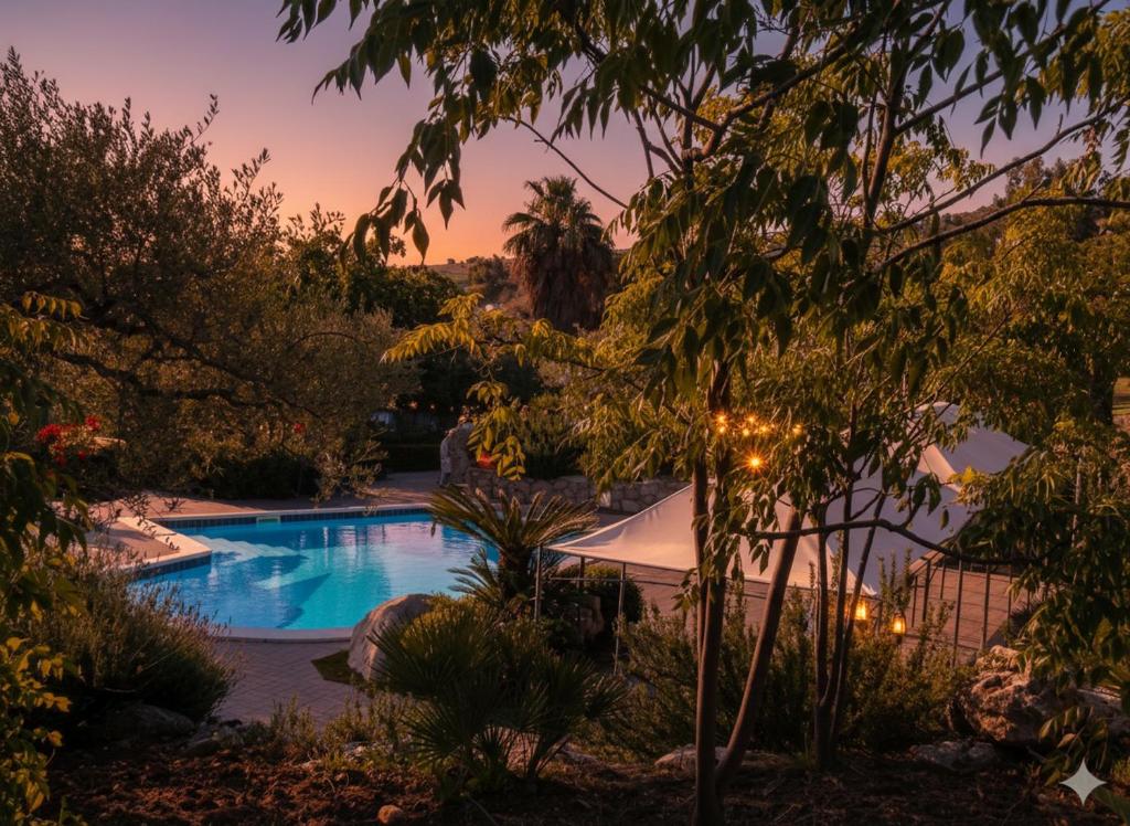ein Swimmingpool in einem Garten mit Sonnenuntergang in der Unterkunft Crapa Licca in Ventimiglia di Sicilia