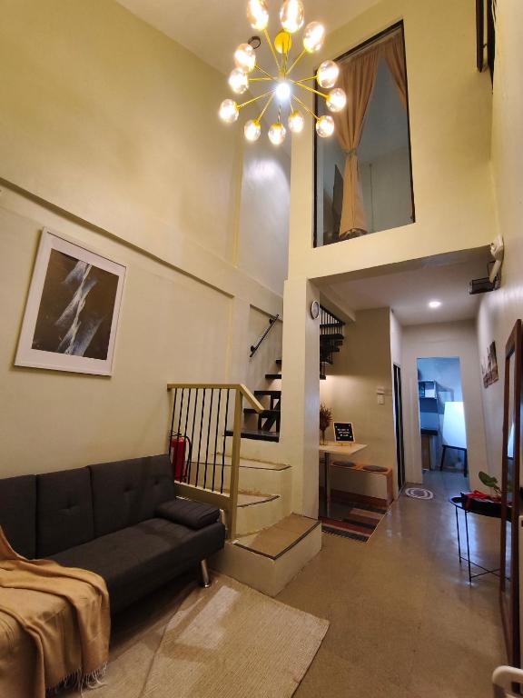 a living room with a couch and a chandelier at Staycation by ALCD in San Mateo