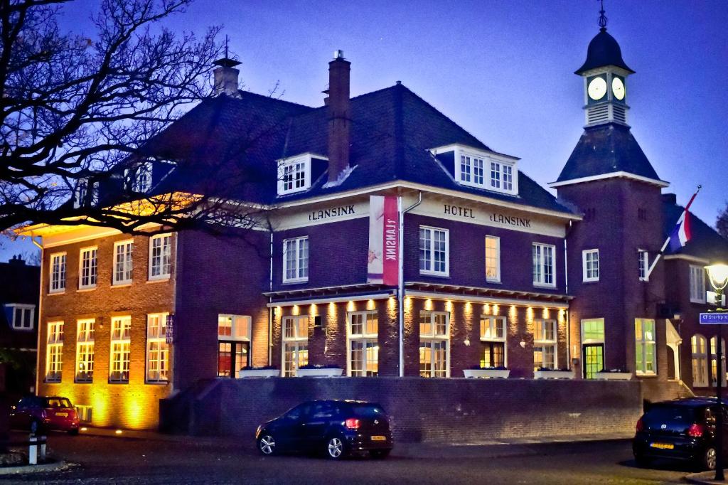 a large building with a clock tower on top of it at Boutique Hotel 't Lansink in Hengelo