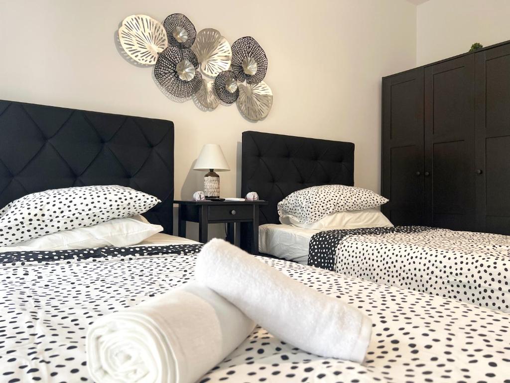 two beds in a bedroom with black and white comforters at Albert's apartment Center 101 in Larnaca
