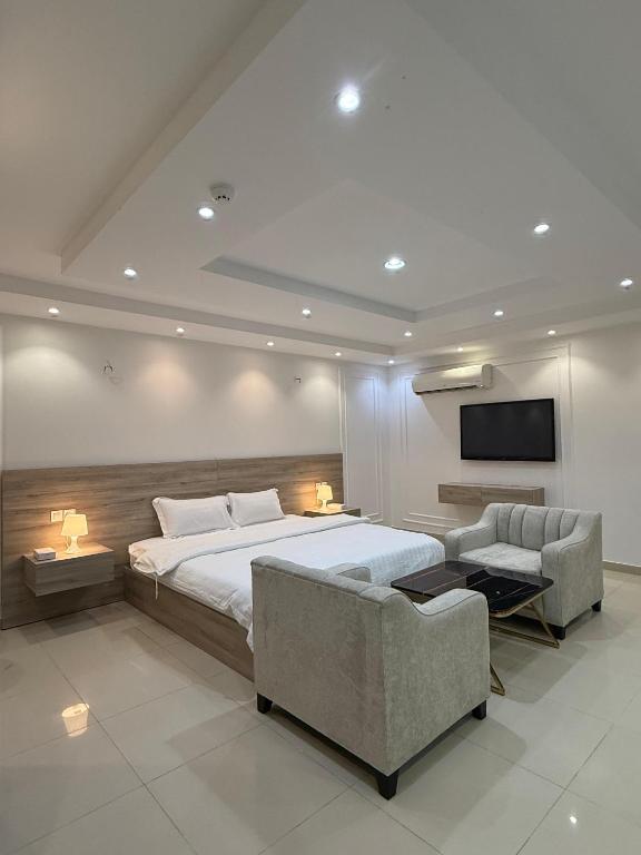 a bedroom with a bed and a couch and a tv at مؤسسة مطلة الورد Matallat Alward Est in Taif