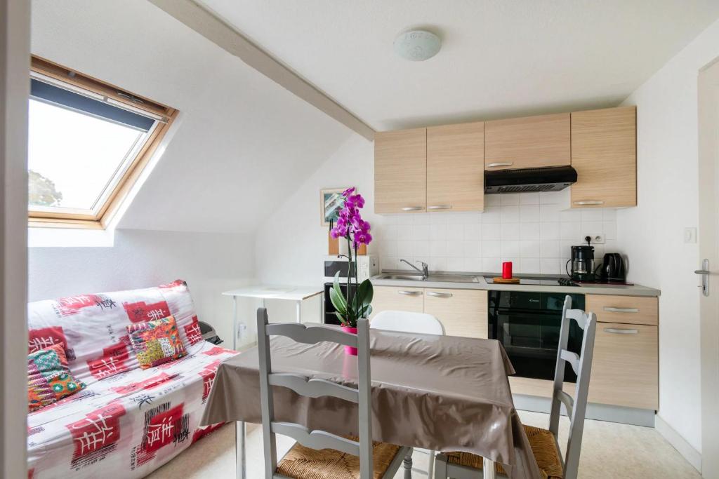 a small kitchen with a table and chairs in a room at Villa MERYEM in Néris-les-Bains