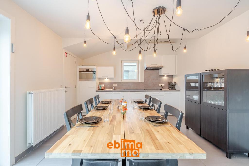 a kitchen with a long wooden table and chairs at Zee en Polder 134 in Middelkerke
