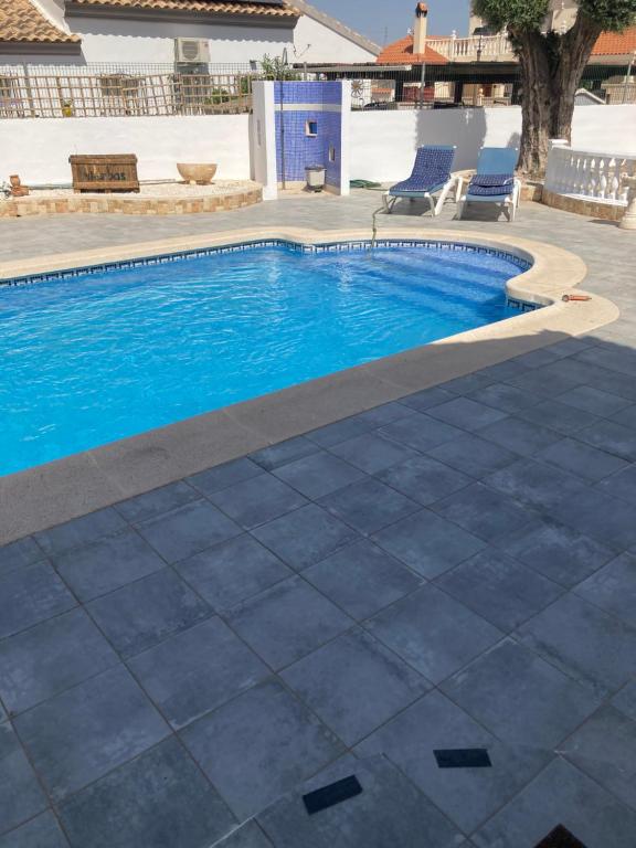 a swimming pool with blue water in a yard at Villa Sparrow, Arboleas in El Arroyo Aceituno