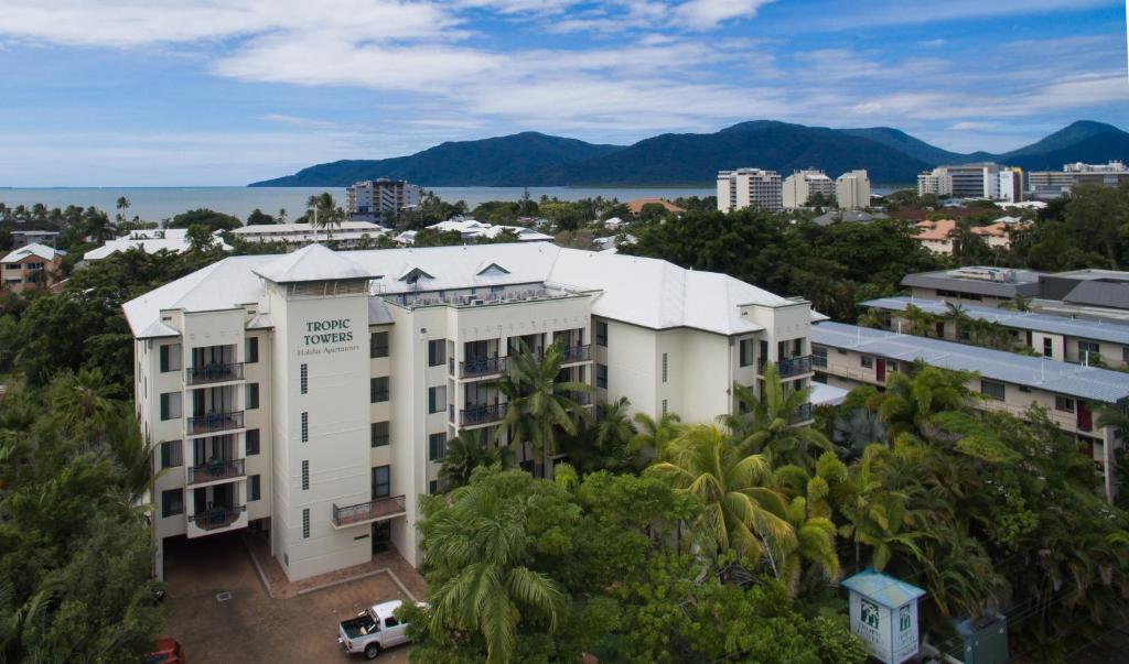 a large building with a lot of windows and trees at Tropic Towers Apartments in Cairns