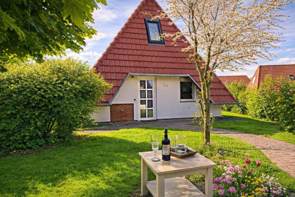 a bottle of wine on a table in front of a house at Weitblick in Dorum-Neufeld