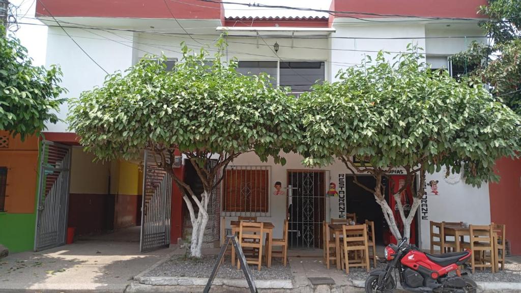 a scooter parked in front of a house with a tree at Alojamientos Fredys in Santa Cruz de Mompox