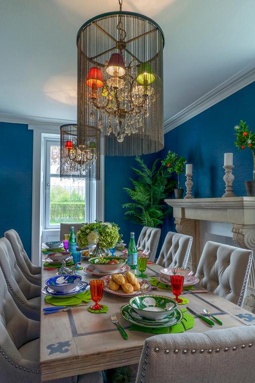 a dining room with a table with food and a chandelier at The Painted Cow in Beattock