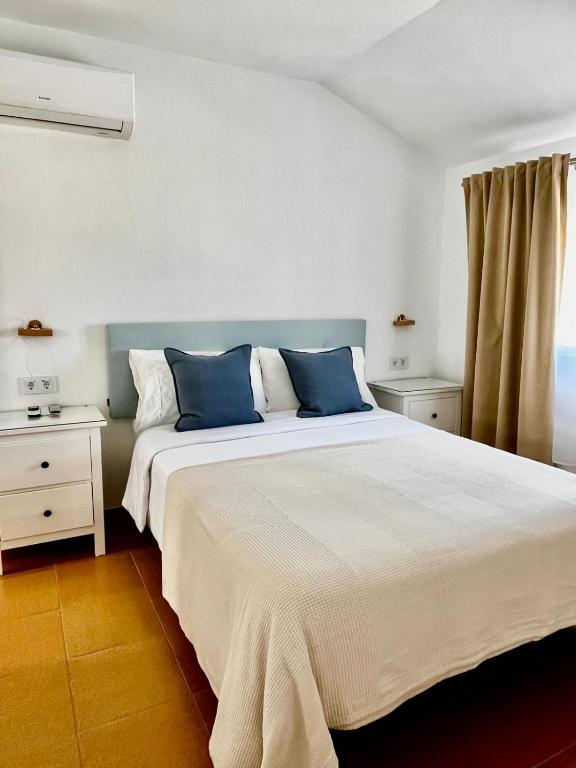 a bedroom with a large bed with blue pillows at Centro Kennedy in Algeciras