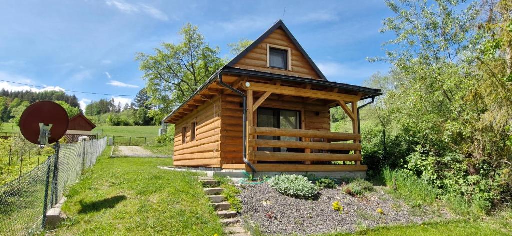 a log cabin in a yard with a fence at Vilka Cibulka a chata Cesnačik in Ižipovce