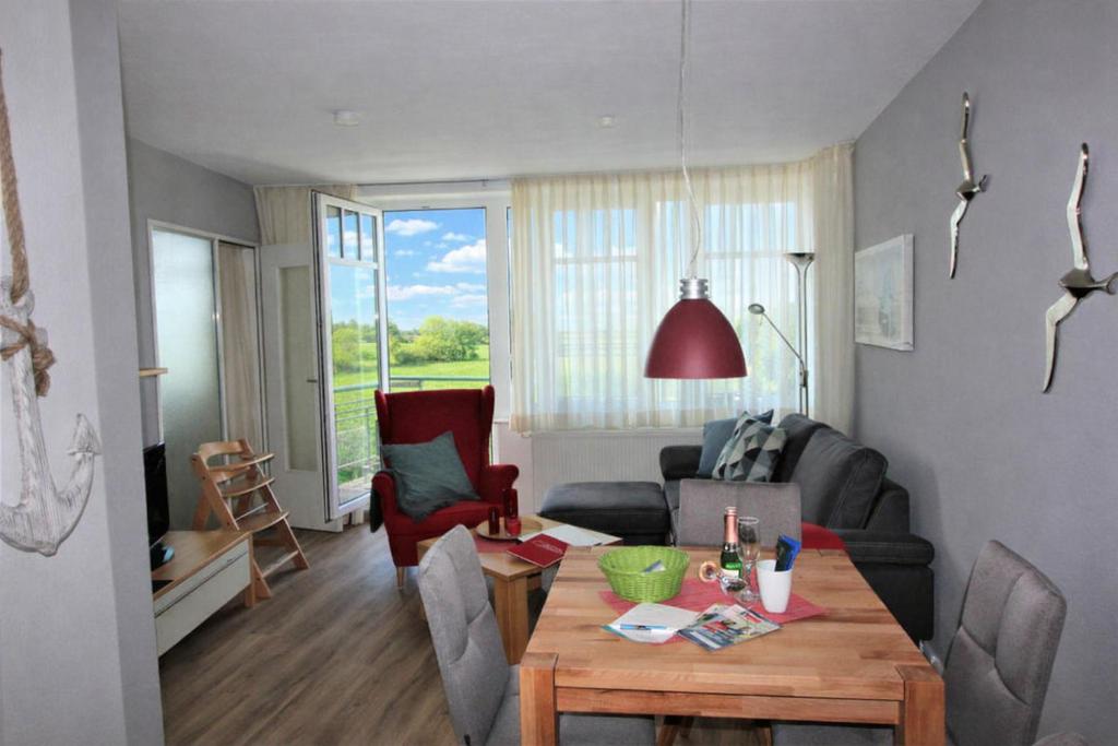 a living room with a table and a couch at de Piepaant in Dorum-Neufeld