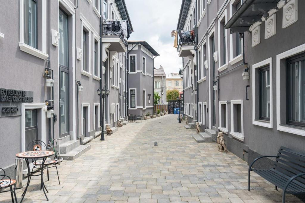 an empty alley with a bench and tables and buildings at AFY STAYS Boutique Apartments in Bucharest