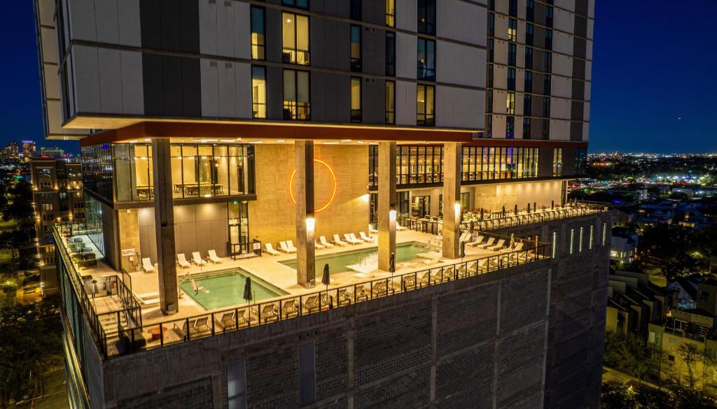 a building with a pool on the side of it at Sentral Forme Houston in Houston
