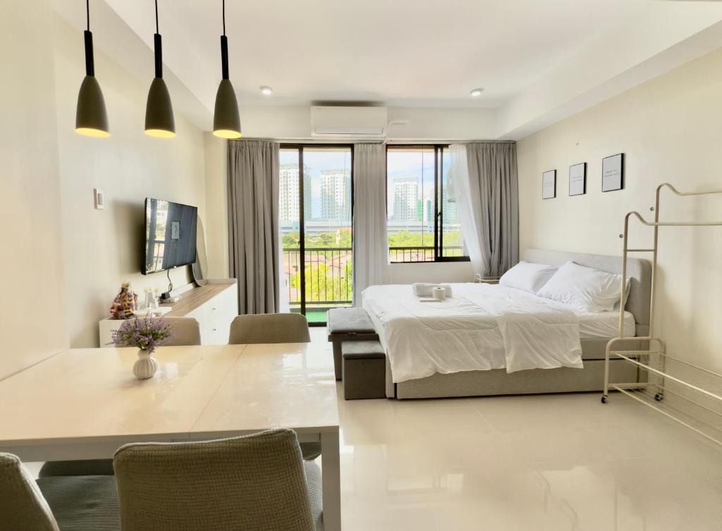 a bedroom with a bed and a table and chairs at Suite Escape Mactan , condo with balcony near Mactan Newtown and Mactan Airport in Mactan