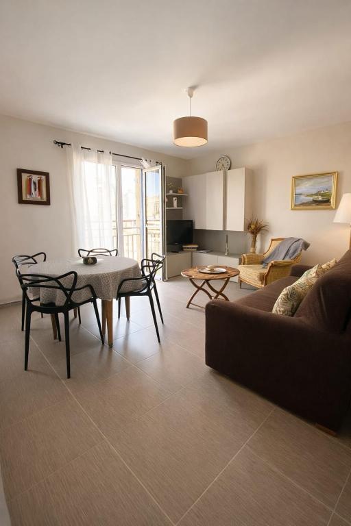 a living room with a couch and a table and chairs at Belle Brise - Cozy apartment in city center in Cancale