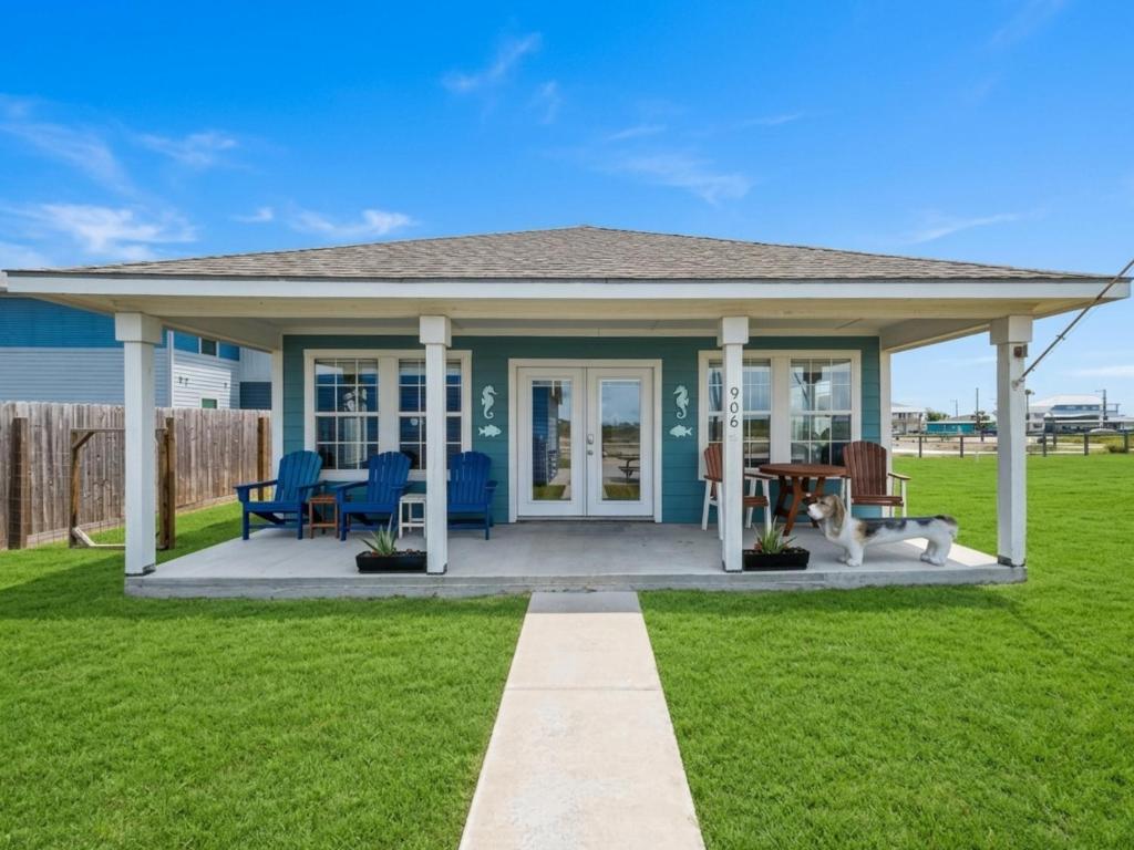 a home with a covered patio with blue chairs at Inn at Dolphin Bay in Rockport
