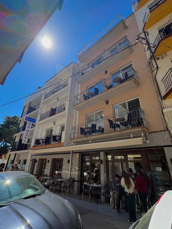 a building with people sitting in front of it at Pensió Anna in Tossa de Mar