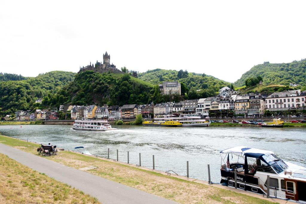 a boat is docked next to a river with buildings at Ferienwohnung am Moselufer in Cochem