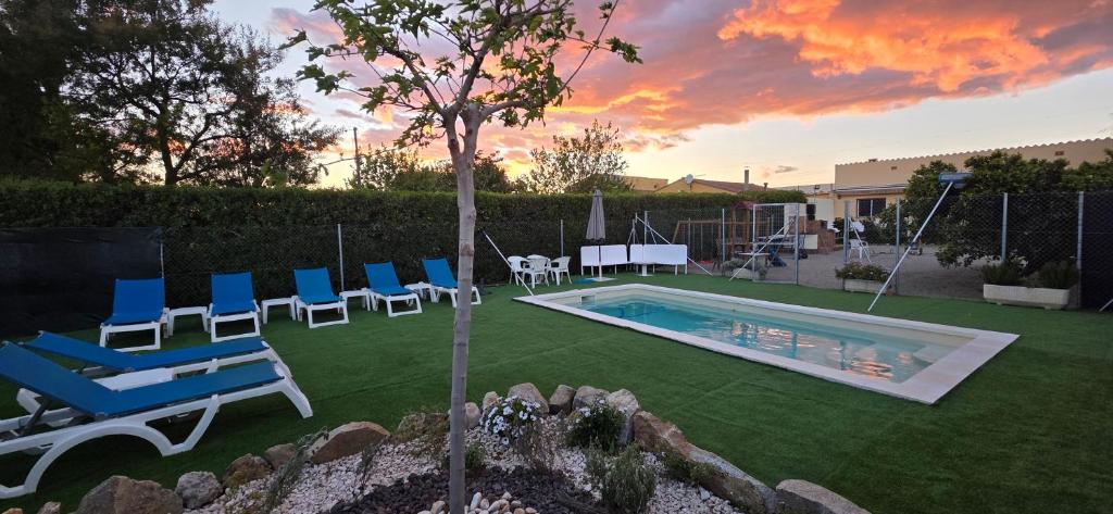 a backyard with a pool and chairs and a table at Mas de la Maria in Cambrils