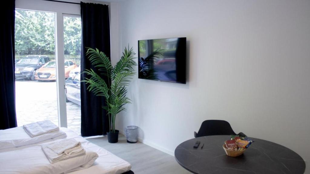 a room with a table and a potted plant at City Apartment - Perfect for two in Tåstrup