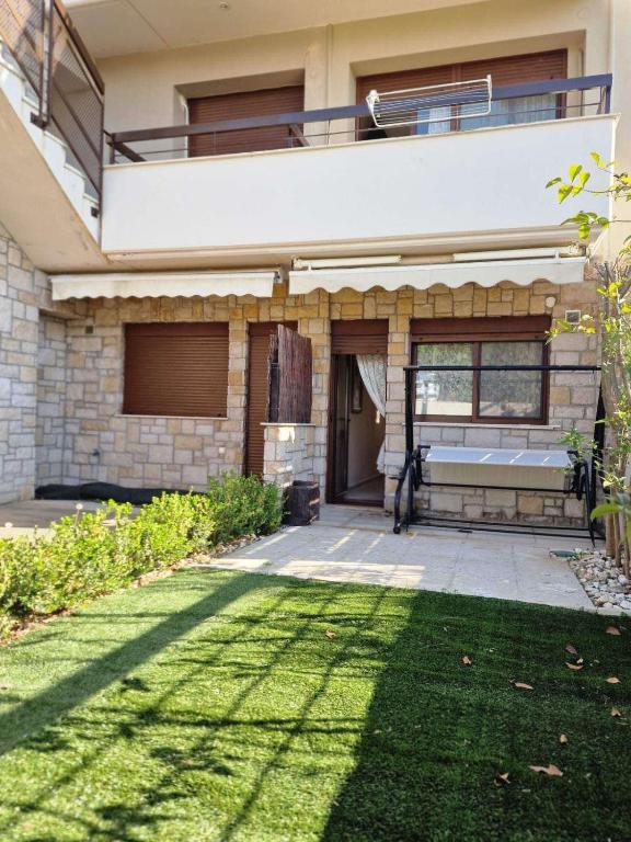 a house with a balcony and a lawn at Lela's House in Yerakiní