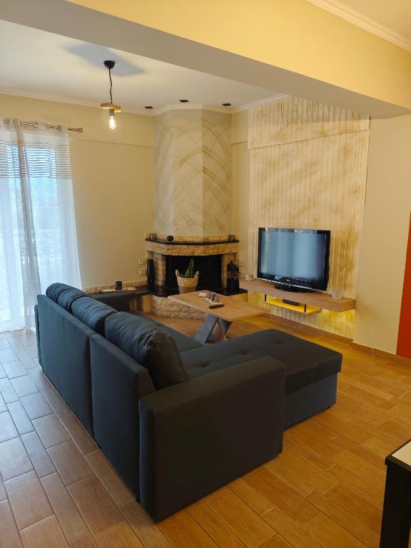 a living room with a couch and a flat screen tv at The Hammam Guest House in Nydri