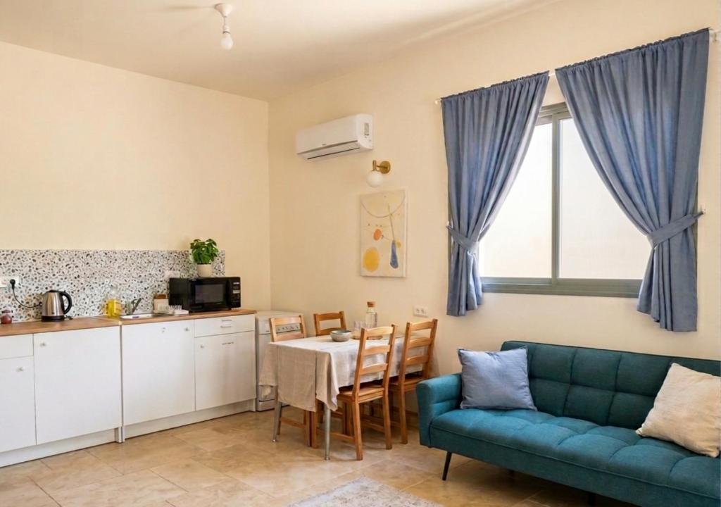 a living room with a blue couch and a table at פינה של נחת במצפה רמון in Mitzpe Ramon