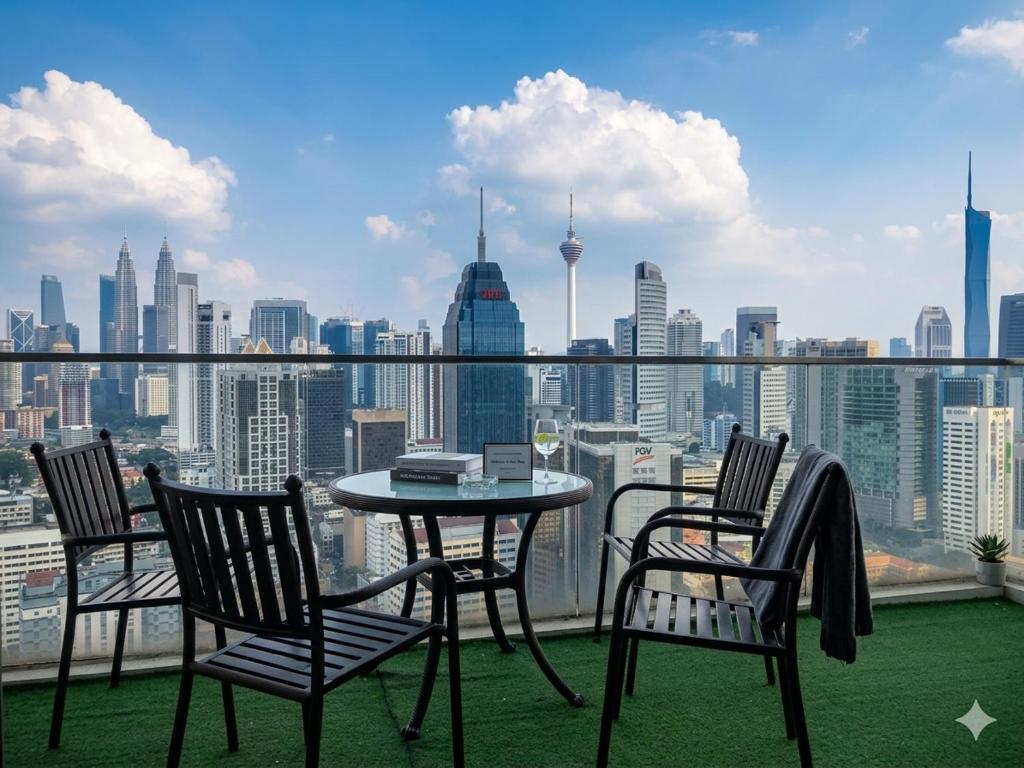 a table and chairs on a balcony with a view of the city at Ehsan Suites in Kuala Lumpur