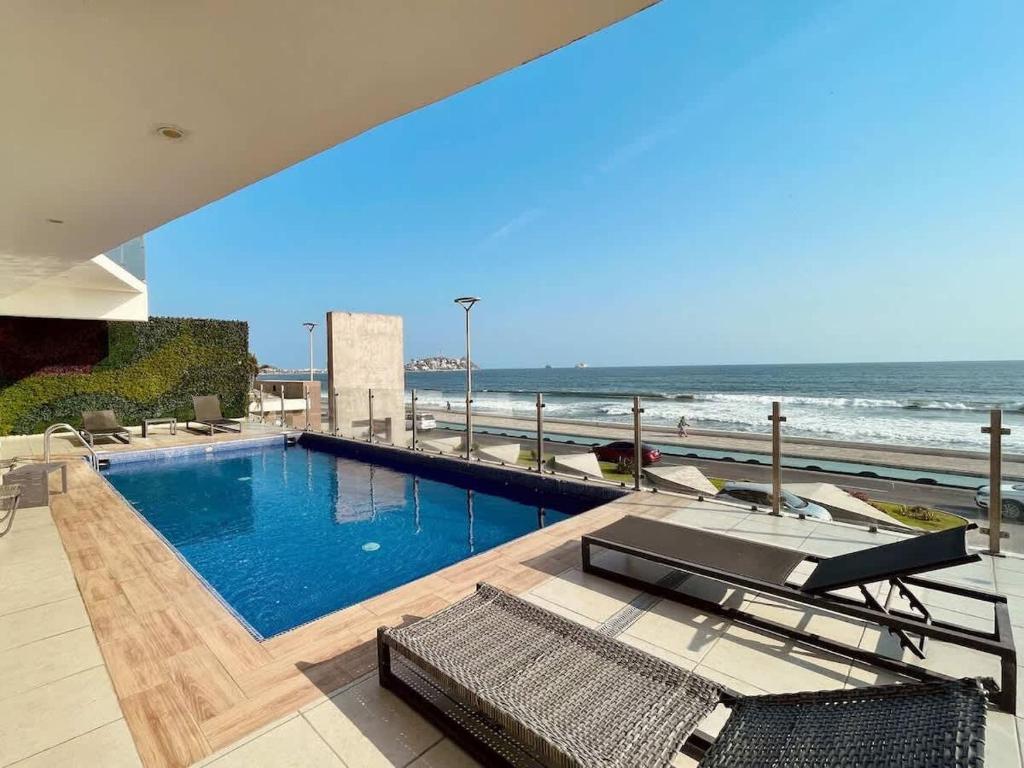 a swimming pool with a view of the ocean at On the Malecón with ocean lagoon & pool in Mazatlán