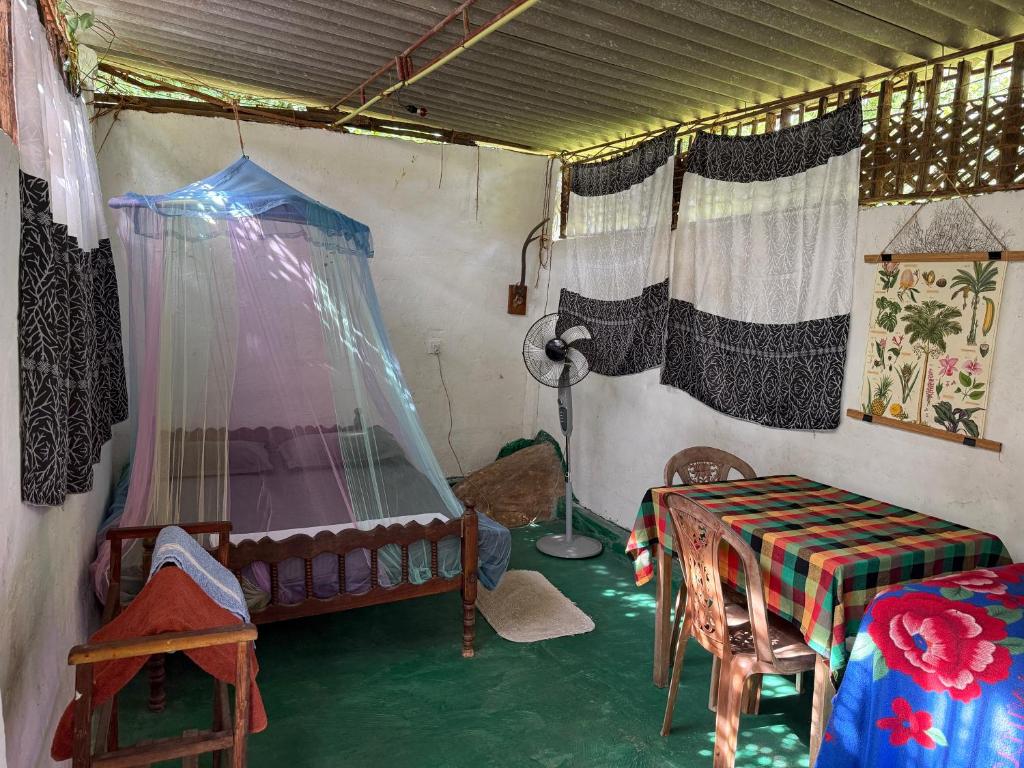 a room with a tent with a bed and a table at Jungle Room in Talalla South